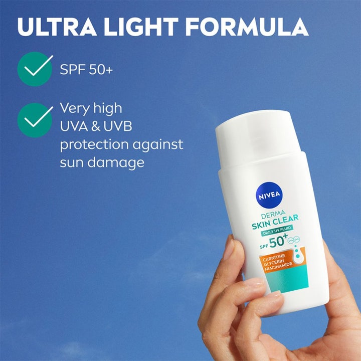 NIVEA Derma Skin Clear Daily UV Fluid 40 ml dagkrem med SPF 50+ hvit flaske i en hånd mot blå himmel med lett formel