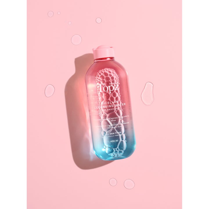 Topz Daily Micellar Cleansing Water 400 ml toner som renser huden i en rosa og blå flaske med bobler og dråper.