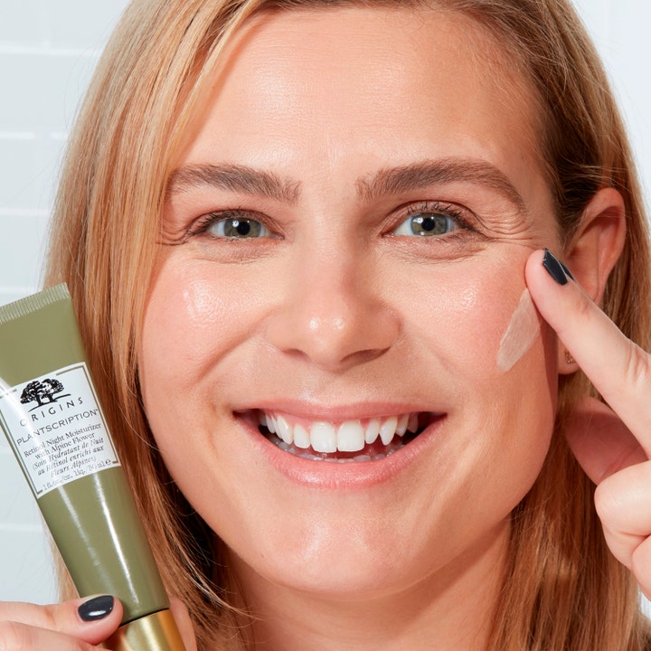 Origins Plantscription Retinol Night Moisturizer 30 ml nattkrem påført av en smilende kvinne fra en grønn tube