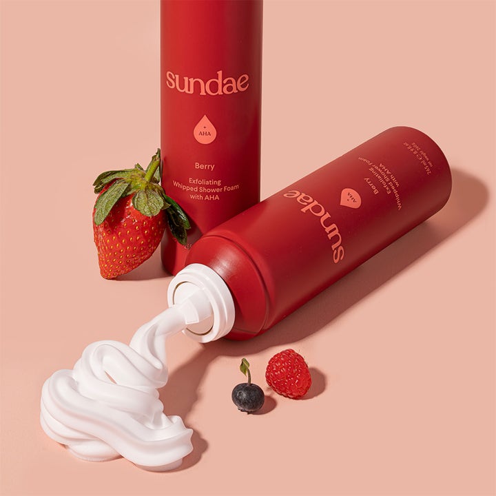 Sundae Whipped Shower Foam Berry AHA 265 ml dusjsåpe med hvitt skum og friske bær på rød bakgrunn