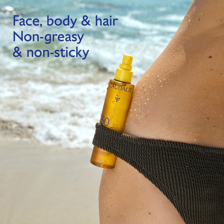Caudalie Vinosun Glow Oil SPF50 150 ml sololje på strand som gir glød til ansikt, kropp og hår