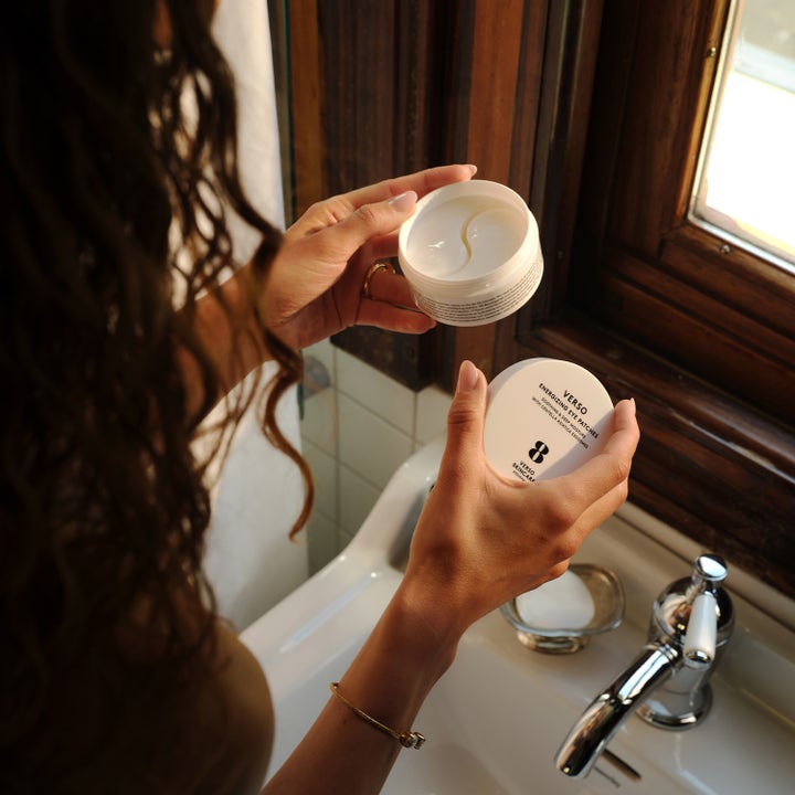 Verso N°8 Energizing Eye Patches 30 stk gir fuktighet i en hvit krukke som holdes åpen over en baderomsvask