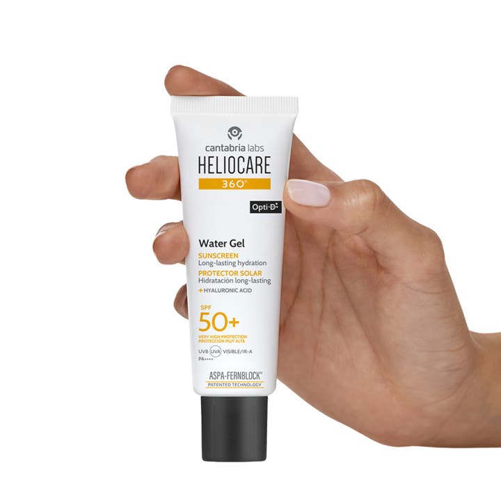 Heliocare Watergel SPF 50+ 50 ml fuktighetsgivende solkrem for ansiktet i hvit tube som holdes av en hånd.