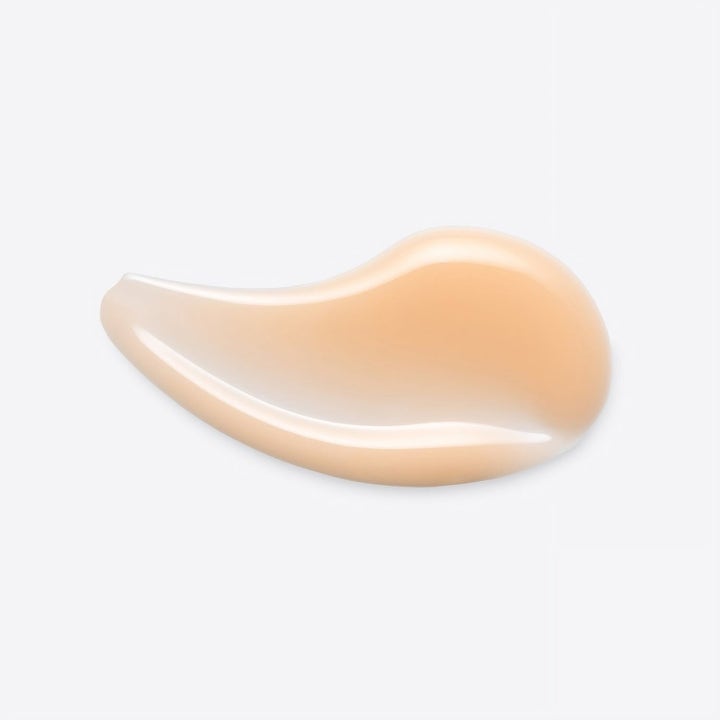 Origins Glow Getter 45 ml lystergivende øyekrem med en ferskenfarget glansfull og kremet tekstursvatch.
