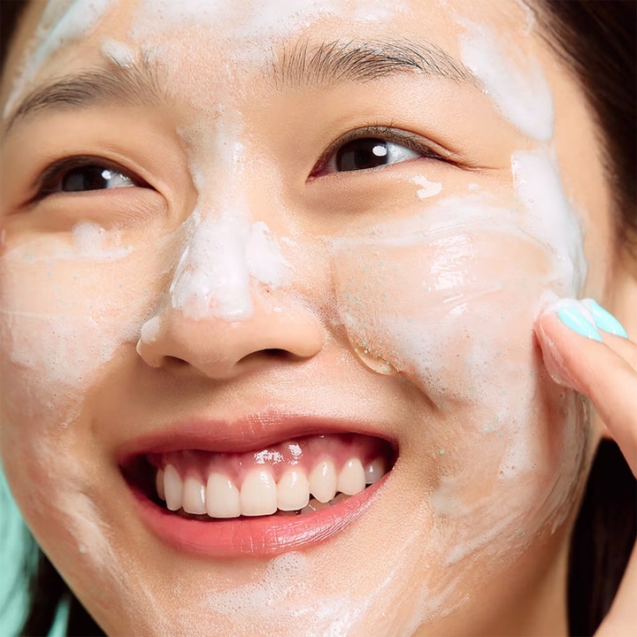 Dr.Jart+ Pore-remedy Renewing Foam Cleanser 150 ml ansiktsrengjøring med eksfolierende skum på en smilende kvinne.
