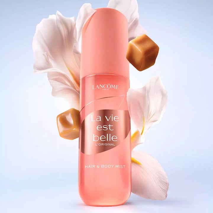 Lancôme La Vie est Belle Hair And Body Mist 100 ml parfymert mist i rosa flaske med hvite kronblader og karamellbiter.