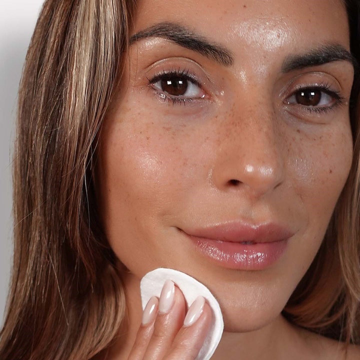 Lavinde Copenhagen Refreshing Micellar Water 250 ml ansiktsrens på en bomullspad mot en kvinnes ansikt.