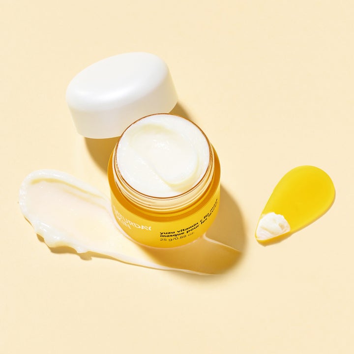 Saturday Skin Yuzu Vitamin C Lip Mask 25 g pleiende leppemaske i gul krukke med kremet tekstur og spatel