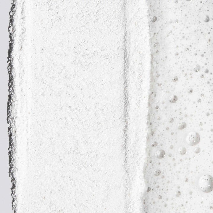 Dermalogica Smoothing Routine Kit eksfolierende ansiktsskrubb med hvit puddertekstur og boblende skum.