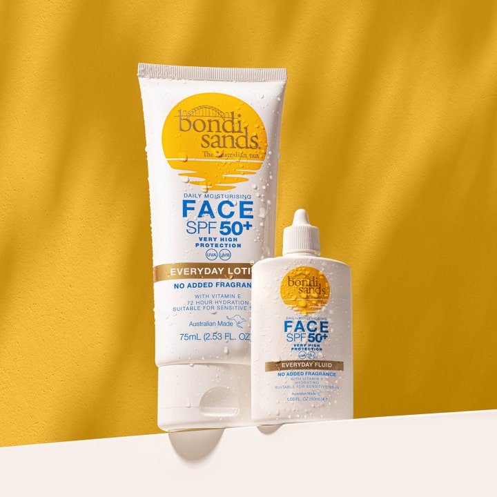 Bondi Sands SPF50+ Everyday Face Fluid 50 ml solkrem for ansiktet i hvit flaske dekket av vanndråper mot gul bakgrunn