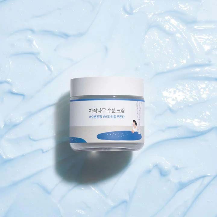Round Lab Birch Juice Moisturizing Cream 80 ml fuktighetskrem i krukke plassert på lyseblå kremet tekstur.