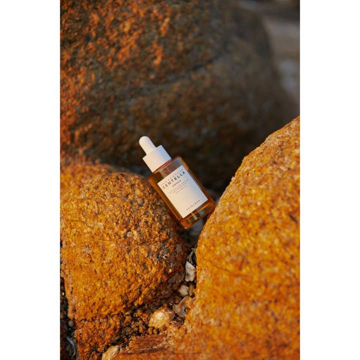 SKIN1004 Madagascar Centella Ampoule 55 ml beroligende serum i glassflaske plassert på gylne steiner