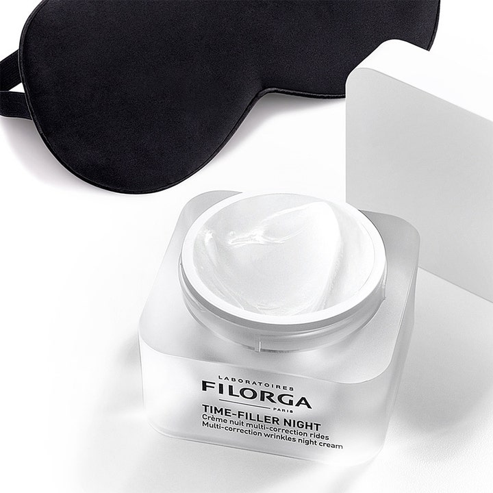 Filorga Time-Filler Night 5 XP 50 ml nattkrem mot rynker i åpen frostet krukke med hvit tekstur og svart sovemaske
