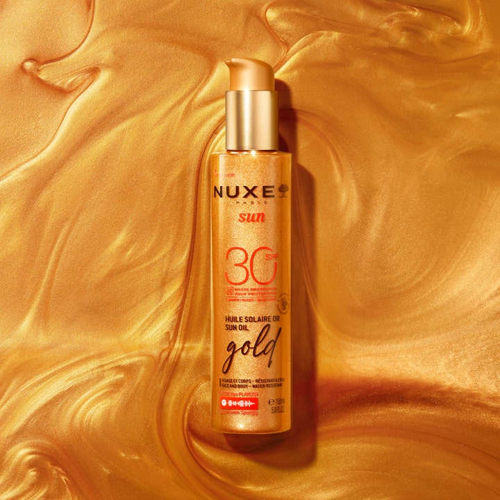 Nuxe Sun Tanning Oil Gold 150 ml sololje med SPF 30 gir glød i gullfarget pumpeflaske på skimrende bakgrunn.