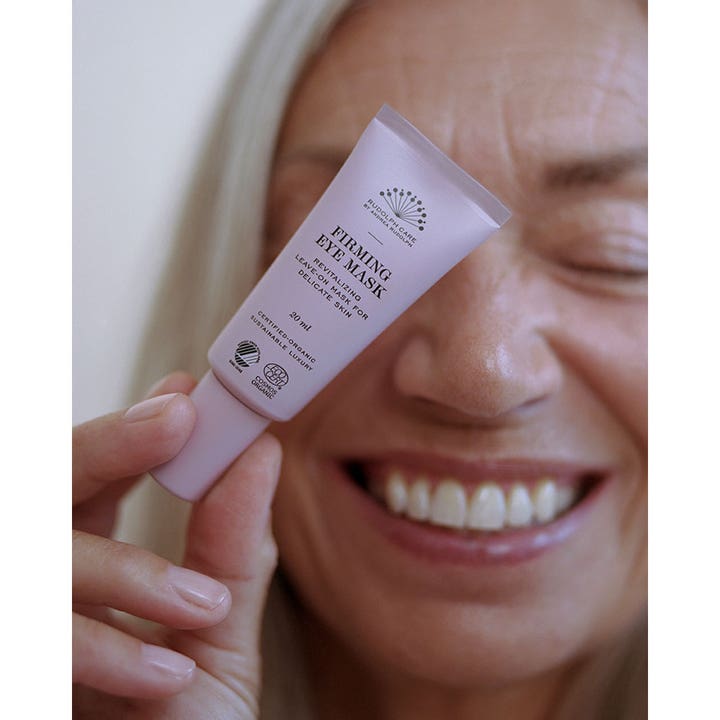 Rudolph Care Firming Eye Mask 20 ml revitaliserende øyekrem som gir fasthet holdt av en smilende kvinne.