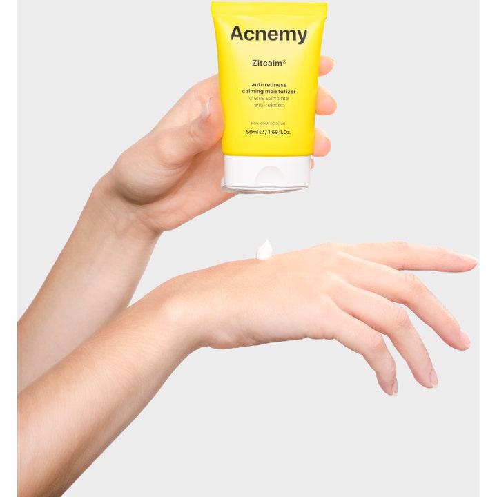 Niche Beauty Lab Acnemy Zitcalm 50 ml ansiktskrem mot rødhet i gul tube som påfører hvit krem på en hånd