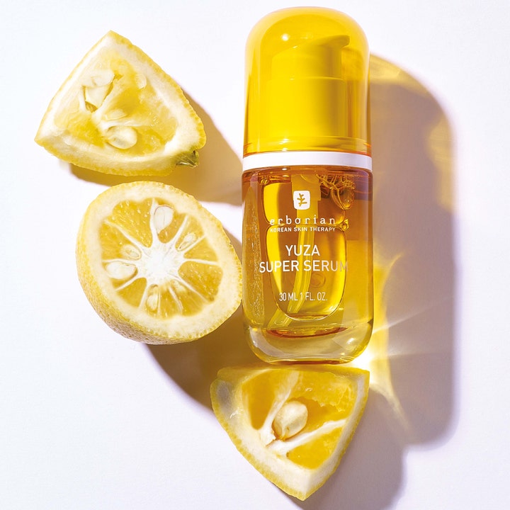 Erborian Yuza Super Serum 30 ml nærende ansiktsserum i gul glassflaske omgitt av friske yuzu-frukter