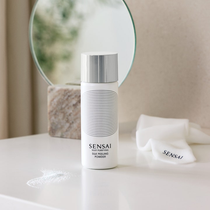 Sensai Silky Purifying Silk Peeling Powder 40 g ansiktsskrubb i hvit flaske med sølvlokk i baderomsmiljø