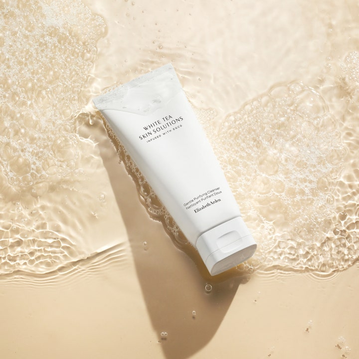Elizabeth Arden White Tea Skin Purifying Cleanser 125 ml rensende ansiktsgel i hvit tube omgitt av vann og skummende bobler