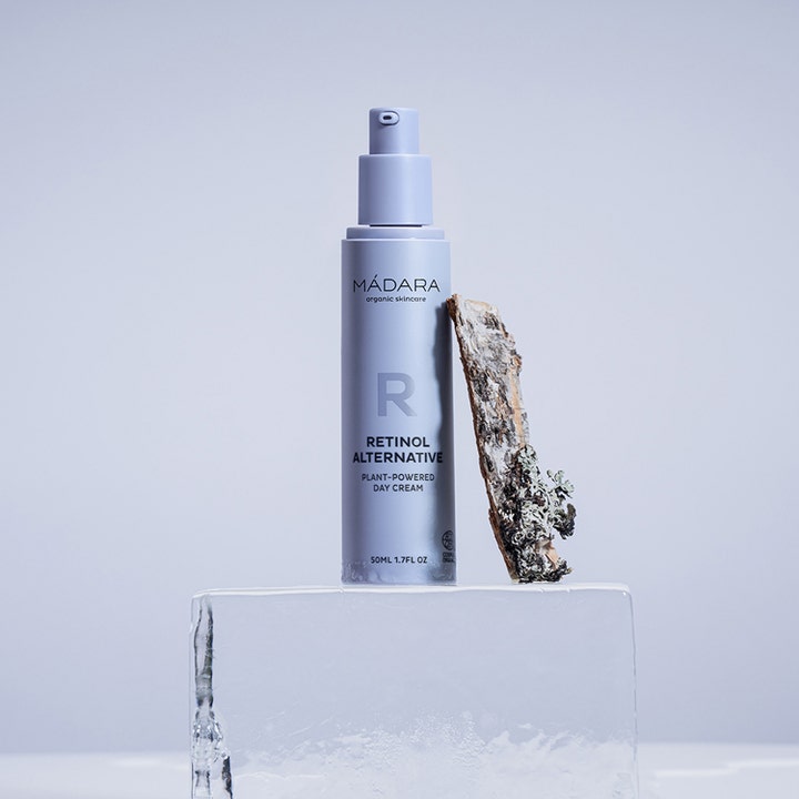 MÁDARA RETINOL ALTERNATIVE 50 ml dagkrem på lilla pumpeflaske ved siden av en barkbit på isblokk