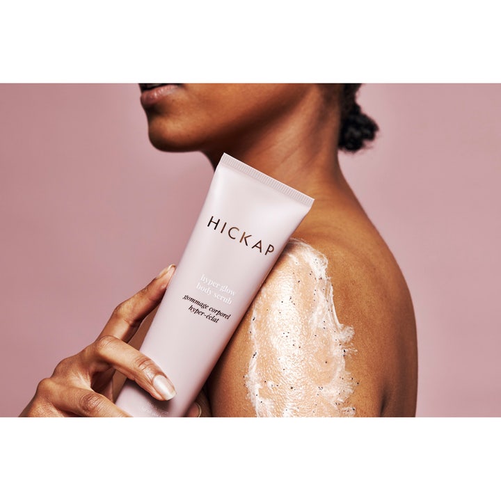 Hickap Hyper Glow Body Scrub 150 ml eksfolierende kroppsskrubb i beige tube påført på skulder for økt glød.