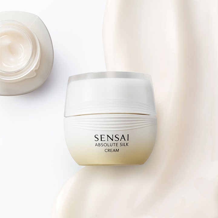 Sensai Absolute Silk Cream 40 ml fuktighetsgivende ansiktskrem i hvit krukke ved siden av fyldig kremtekstur.