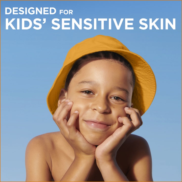 Garnier Ambre Solaire Sensitive Advanced Kids 270 ml solkrem med smilende barn i gul hatt mot blå himmel
