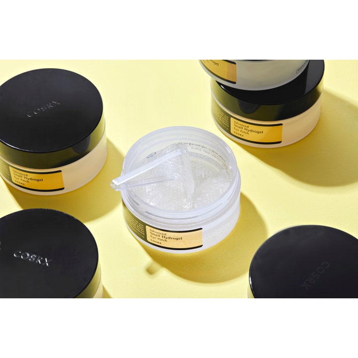 COSRX Advanced Snail Hydrogel Eye Patches 60 stk fuktighetsgivende øyepatcher i åpen boks med klar gel og spatel