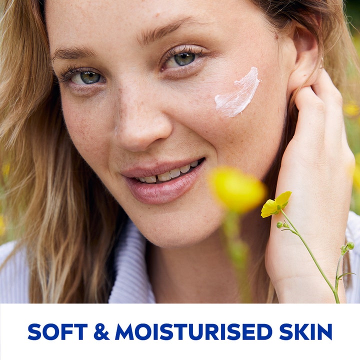 NIVEA Soft 200 ml fuktighetskrem gir myk og fuktet hud vist med hvit krem på kinnet til en kvinne.