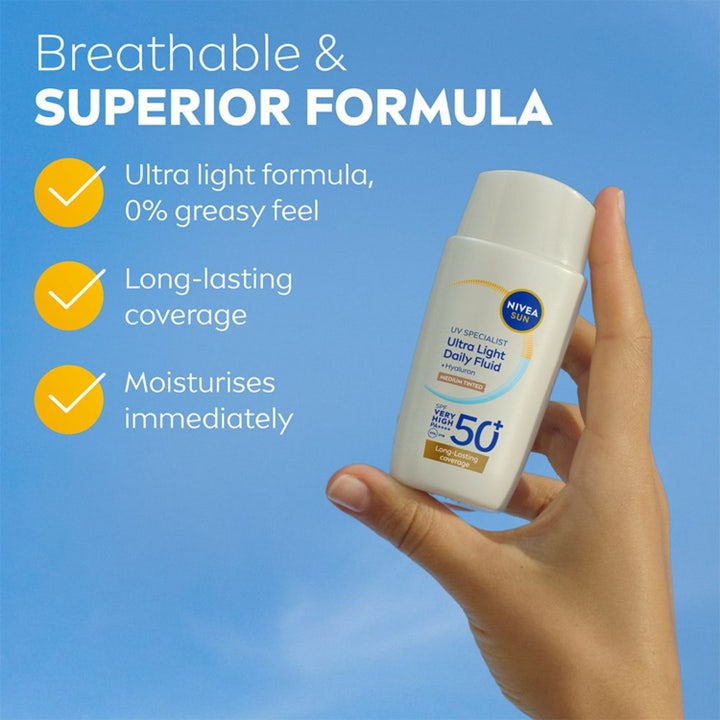 NIVEA UV Face Ultra Fluid Medium Tinted 40 ml solkrem til ansikt SPF 50+ gir fuktighet og holdes mot blå himmel.