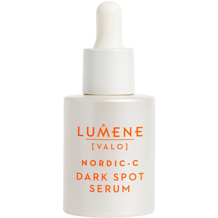 Lumene Nordic-C Dark Spot Serum for jevnere hudtone i en perlehvit glassflaske med hvit pipette og oransje tekst.