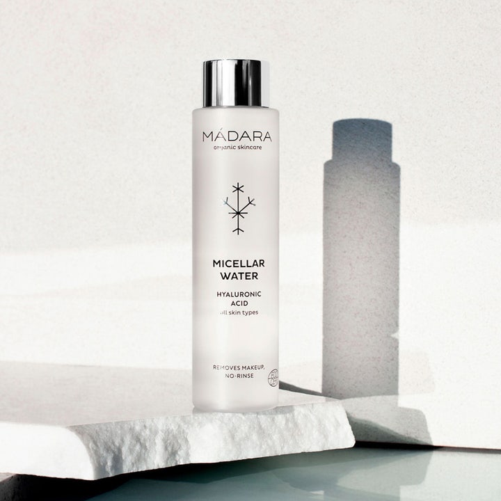 MÁDARA Micellar Water 100 ml ansiktsrengjøring med hyaluronsyre i frostet flaske med sølvkork på hvit steinflate
