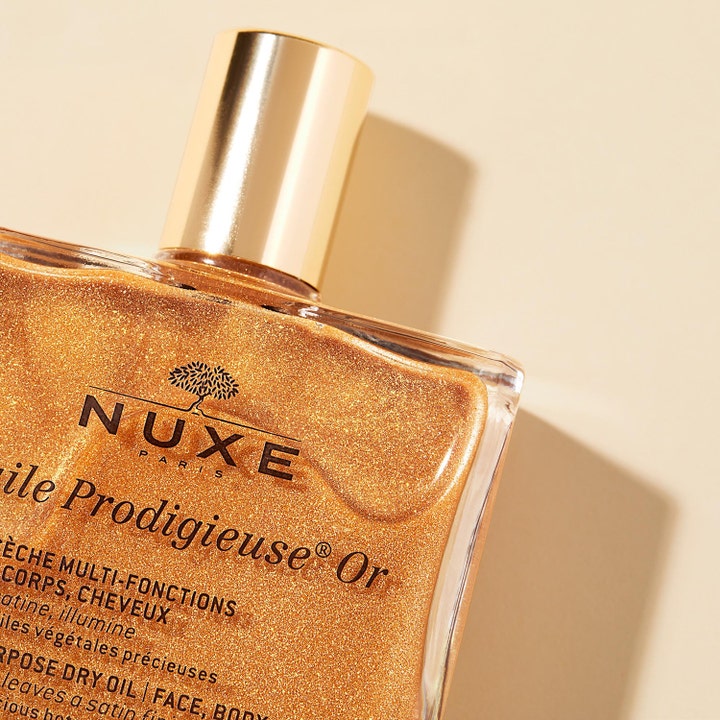 Nuxe Huile Prodigieuse Or 50 ml glødgivende tørrolje i glassflaske med skimrende gullkorn og gullkork.