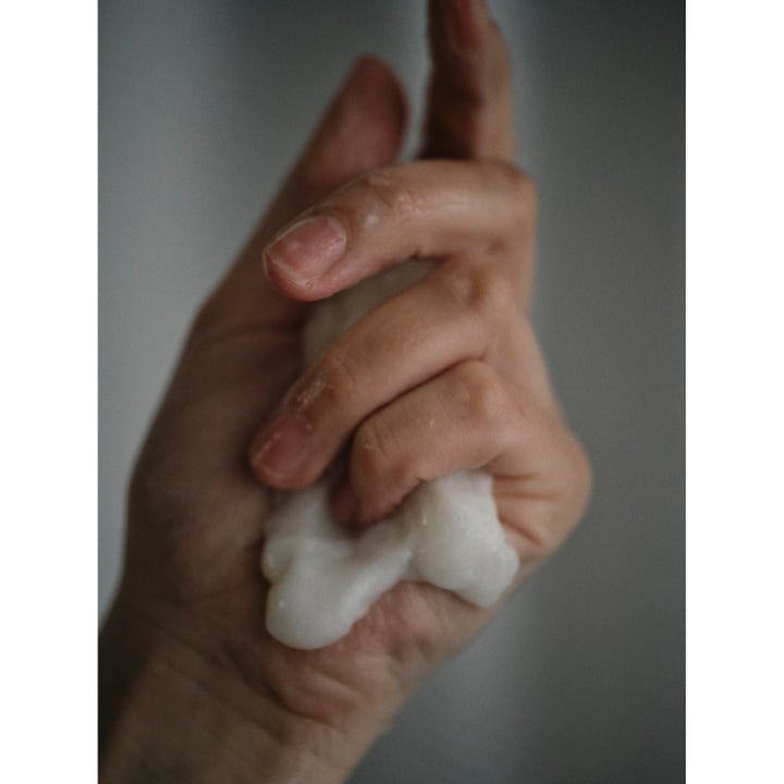Rudolph Care Hand And Body Cream 500 ml pleiende bodylotion med rik hvit tekstur i en hånd
