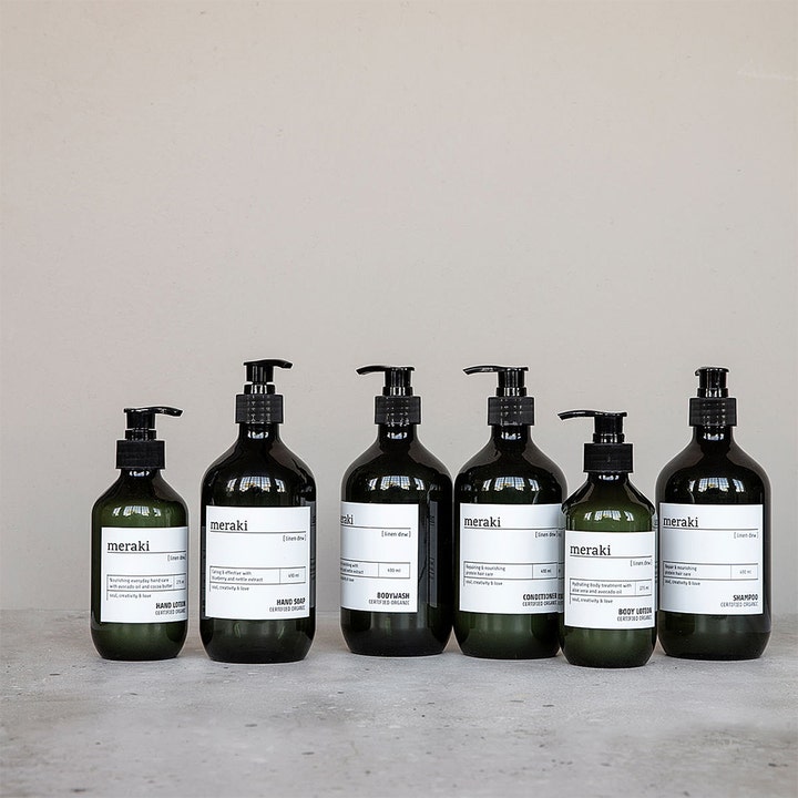 Meraki Linen Dew Hand Lotion 275 ml fuktighetsgivende håndkrem i mørk pumpeflaske vist i en produktserie