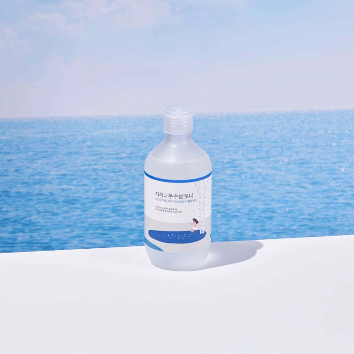 Round Lab Birch Juice Moisturizing Toner 300 ml fuktighetsgivende toner i klar flaske foran blått hav