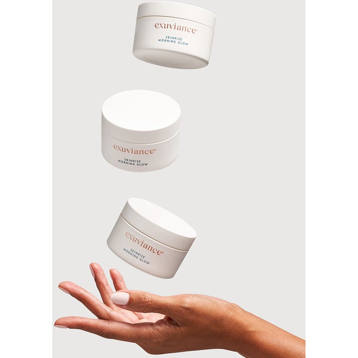 Exuviance SkinRise Morning Glow 36 stk glødgivende serum pads i hvite krukker svevende over en hånd
