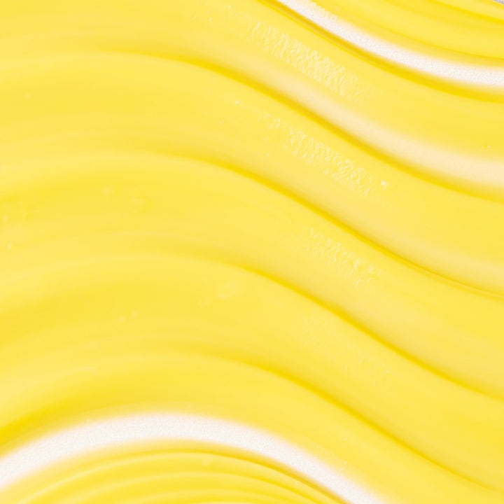 KORA Organics Turmeric Glow Moisturizer 50 ml fuktighetsgivende dagkrem med en fyldig gul og kremet bølgeformet tekstur.