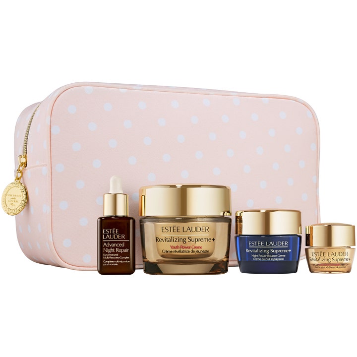 Estée Lauder Revitalizing Supreme+ 4 deler hudpleiesett som gir glød i rosa prikkete mappe med serum og gullfargede krukker.