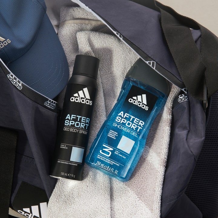 Adidas After Sport 250 ml fuktighetsgivende dusjsåpe i en treningsbag sammen med et grått håndkle og deospray