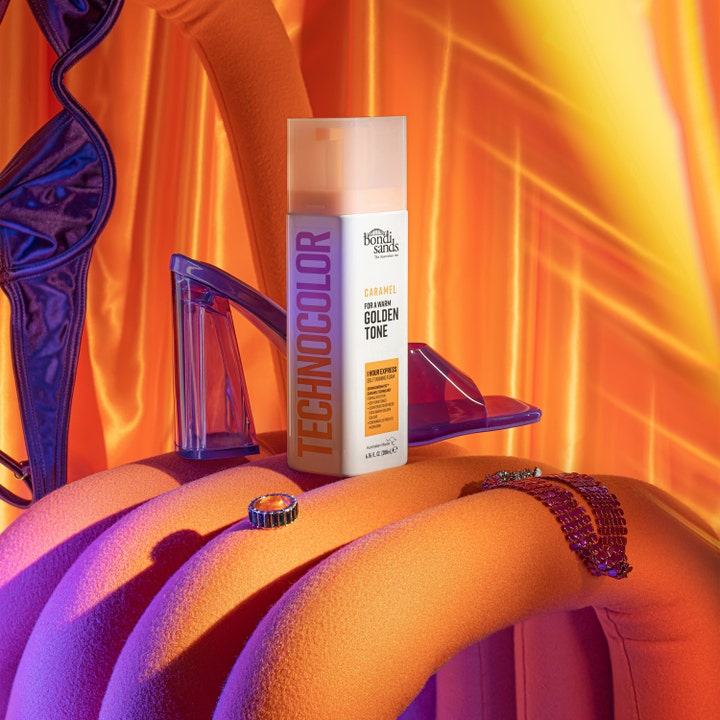 Bondi Sands Technocolor Self Tanning Face Serum Caramel 50 ml skaper gyllen glød vist med lilla sko og varmt lys