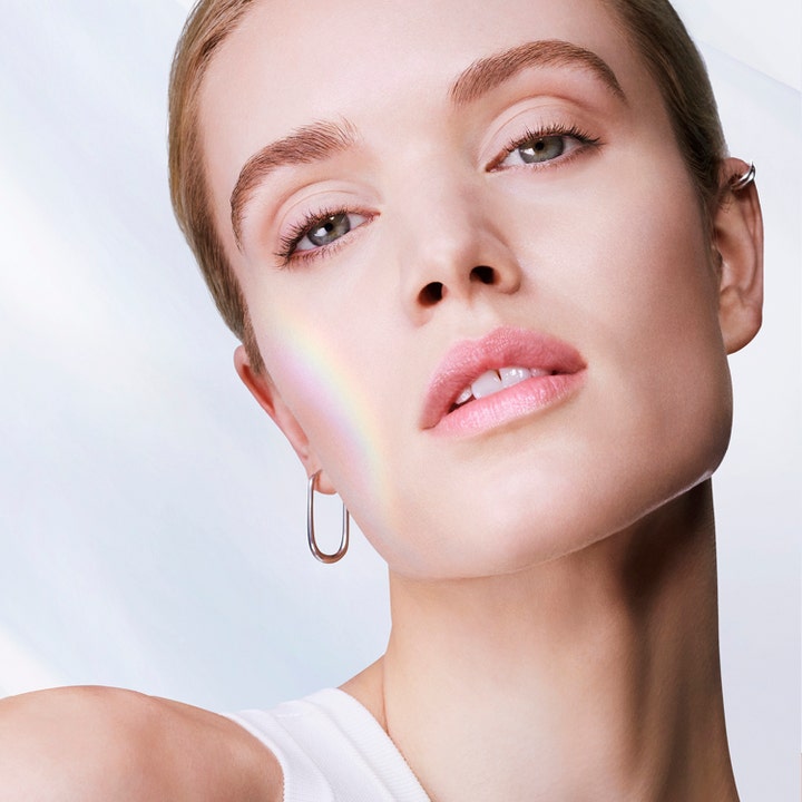 Lancôme UV Expert Supra Screen SPF50 40 ml solkrem gir glød til ansiktet vist på en modell med lys hud