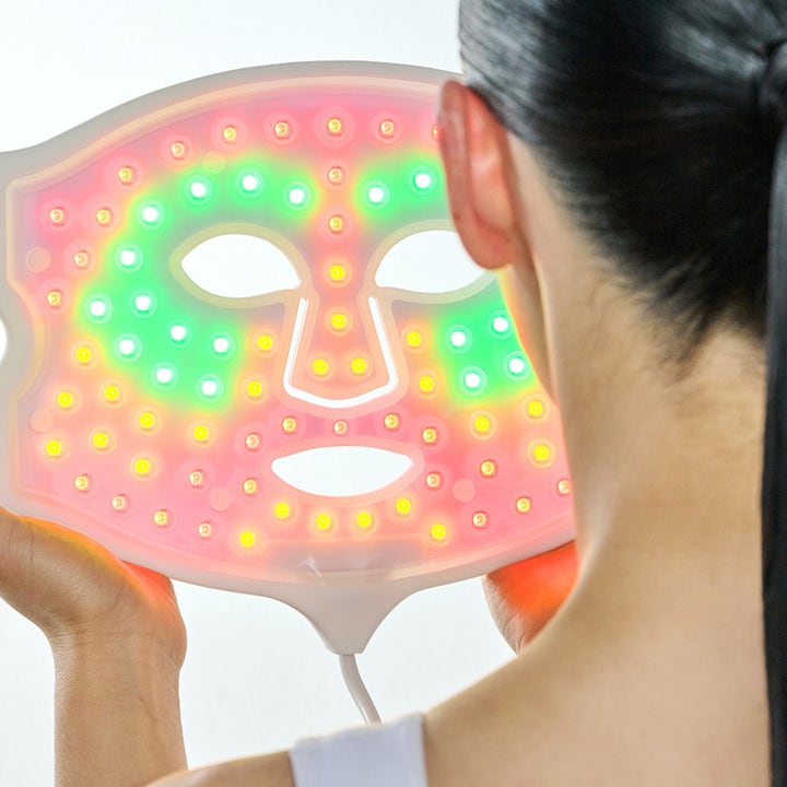 Currentbody Skin LED 4-in-1 Mask hudpleieenhet som gir glød med lysende røde, grønne og gule LED-lys.