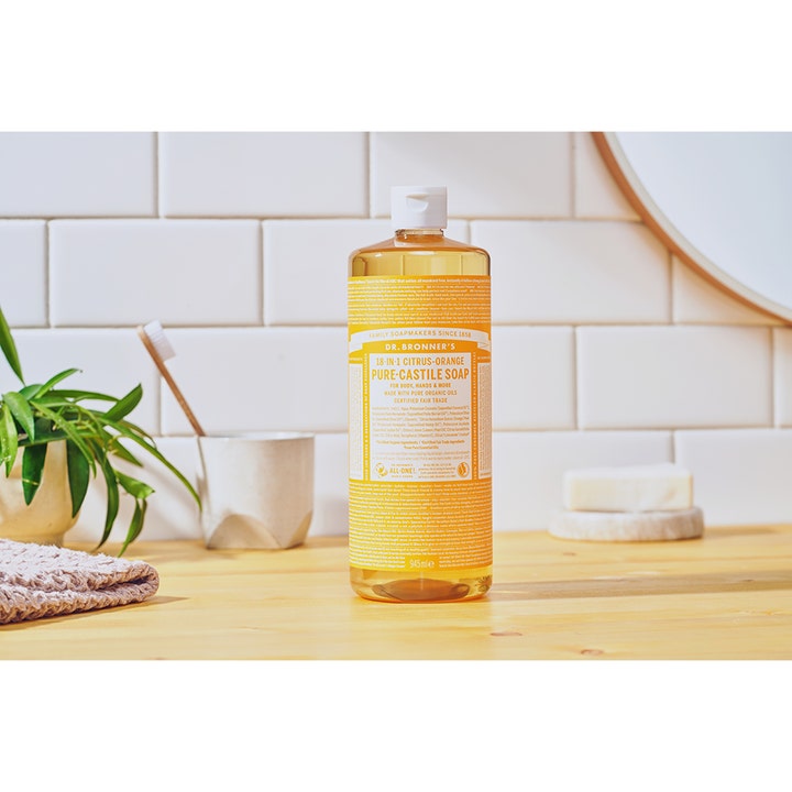 Dr. Bronner's Pure Castile Liquid Soap Citrus-Orange 945 ml oppfriskende såpe i stor flaske på en lys baderomsbenk.