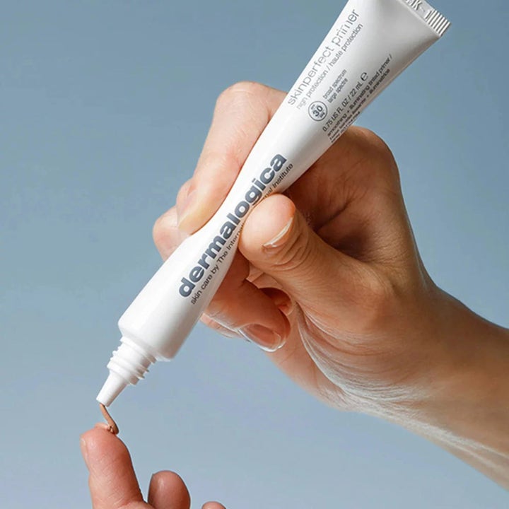 Dermalogica AGE smart Skinperfect Primer SPF30 22 ml utjevnende solkrem for ansiktet i hvit tube på en fingertupp.