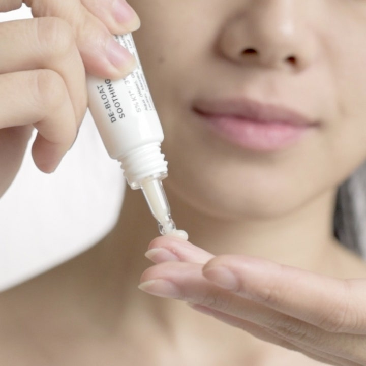 Niche Beauty Lab Transparent Lab De-Bloat Soothing Eye Serum 15 ml beroligende øyeserum som klemmes ut på en finger
