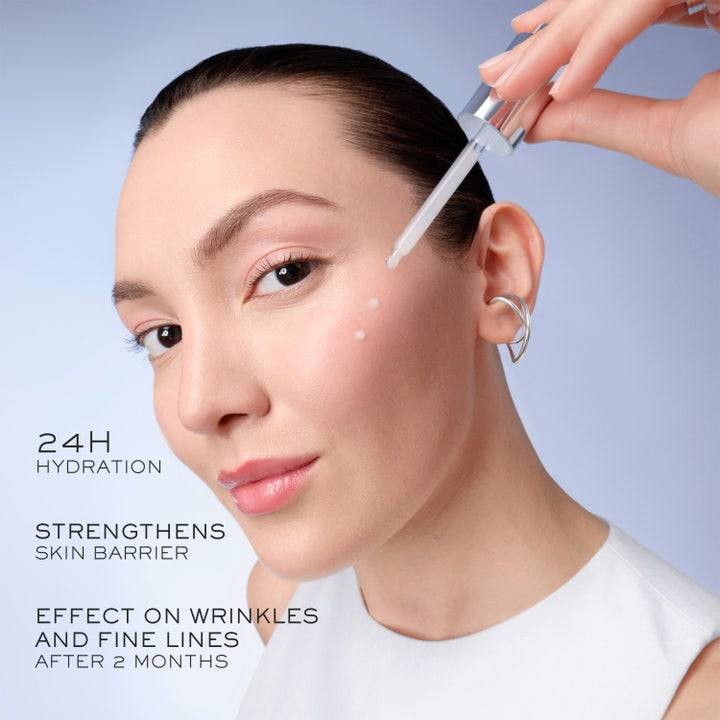 Lancôme Génifique Ultimate Serum 50 ml reparerende ansiktsserum med en pipette over en lysende blå kule
