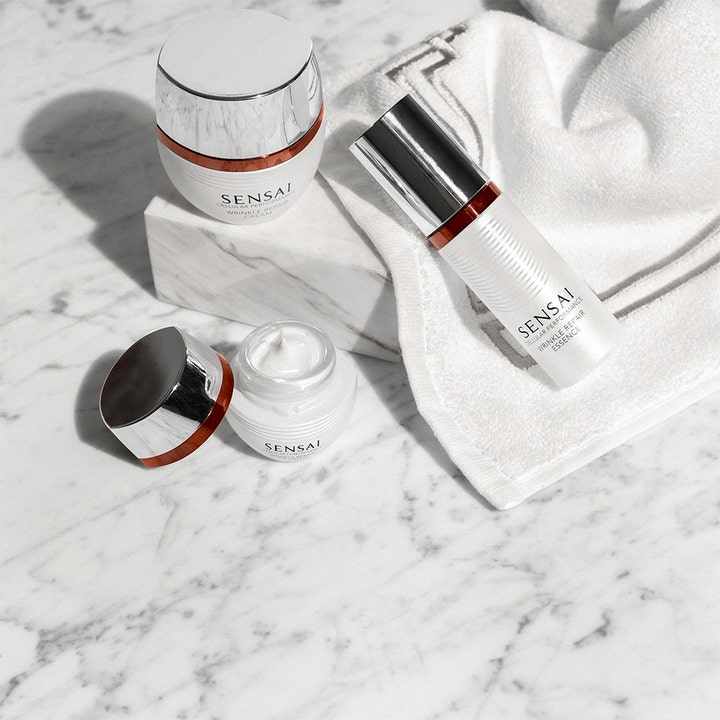 Sensai Cellular Performance Wrinkle Repair Essence 40 ml rynkereduserende essence i hvit flaske på et hvitt håndkle