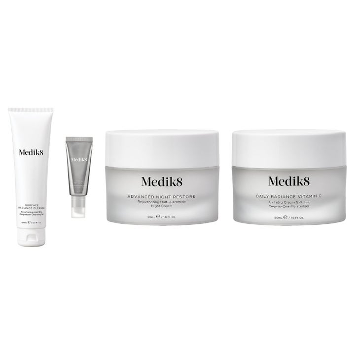 Medik8 Hudpleiesett for glød og anti-age med rens og serum i hvite og sølvfargede tuber samt krukker i frostet glass.