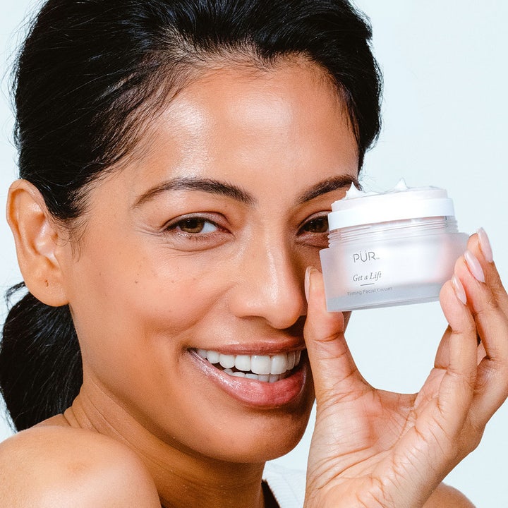 PÜR Get A Lift Cream 50 ml oppstrammende ansiktskrem i frostet glasskrukke holdt av en smilende kvinne.